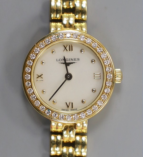 A lady's 18ct gold Longines quartz wrist watch, with mother of pearl dial and diamond chip set bezel, on an 18ct gold Longines bracelet, approx. 16cm, gross weight 33.2 grams, no box or papers.